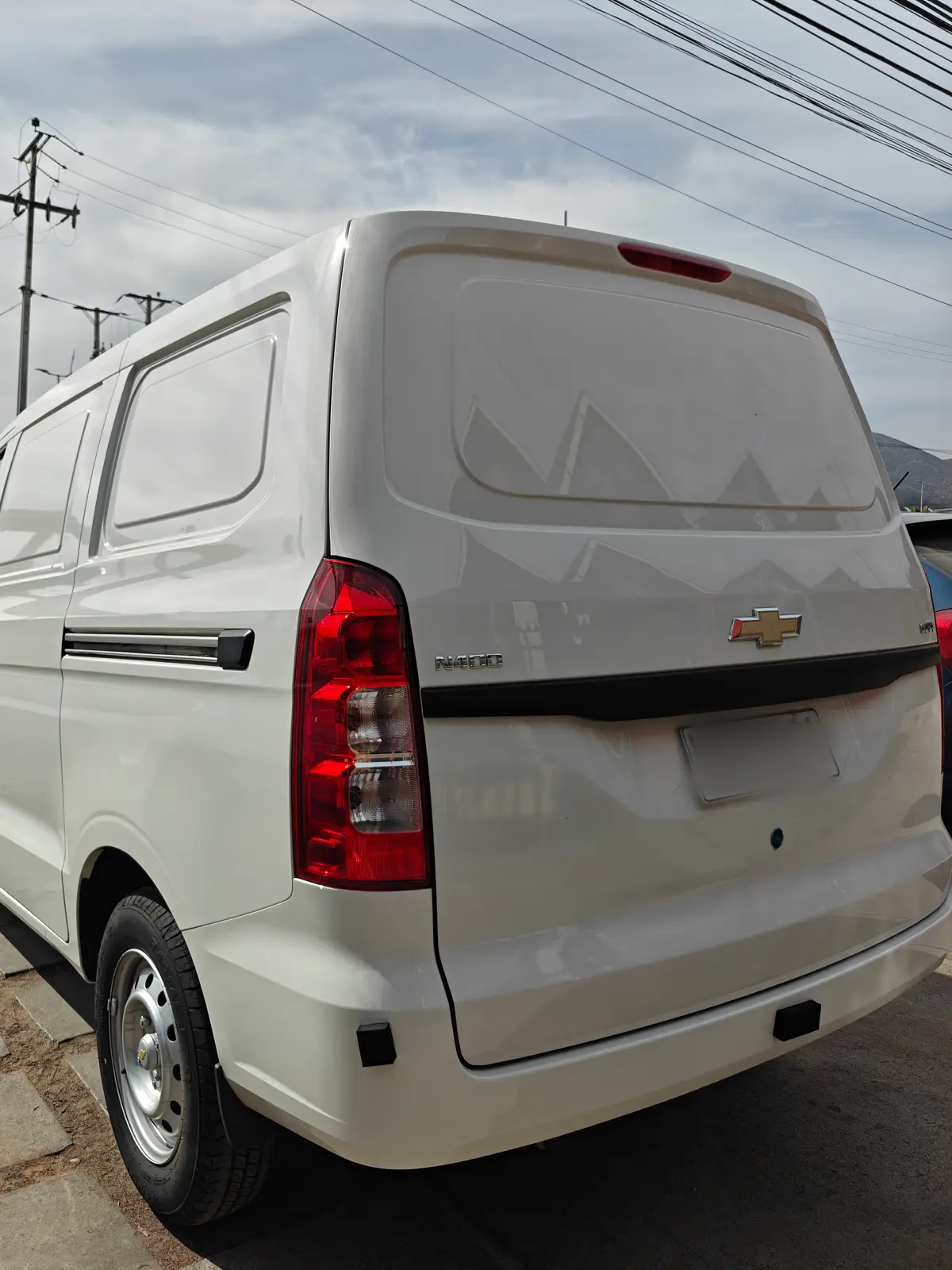 Furgón blanco de Vango visto desde atrás, estacionado junto a la calle
